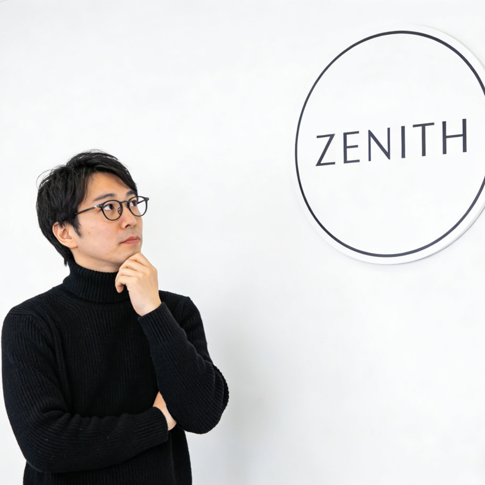 하얀 벽에 있는 제니스(Zenith) 간판을 바라보는 사람의 모습을 담은 미니멀리스트 브랜드 아이덴티티 장면